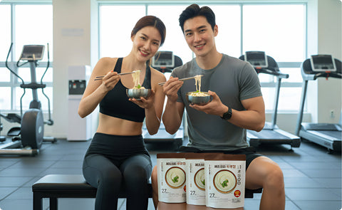 a man and a woman eating haechomiin noodle at the gym