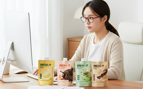 a woman working with 4 variants of meal it protein shake displayed